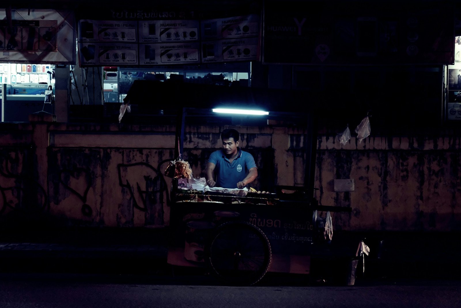 man standing beside food stand